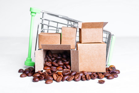 Overturned miniature shopping trolley with tiny cardboard boxes with roasted coffee beans isolated on white background. Store delivery concept.の写真素材