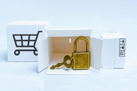 Group of small marked delivery boxes and tiny padlock with a key. E-commerce privacy protection concept.の写真素材