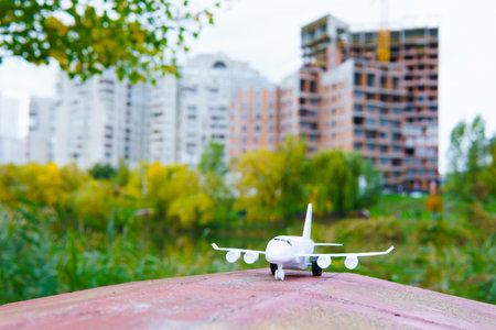 Toy airplane outdoors against a city background.の写真素材