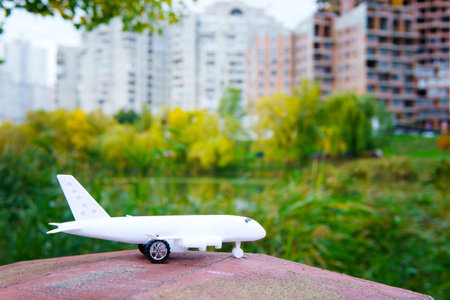 White toy plane outdoors against a town background.の写真素材