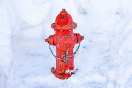Red fire hydrant in a snowdrift. Winter safety concept.の写真素材