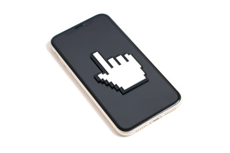 Pixelated plastic pointer cursor shape placed on a smartphone's screen isolated on white background. Web and graphic design, advertising and social media related concept.の写真素材