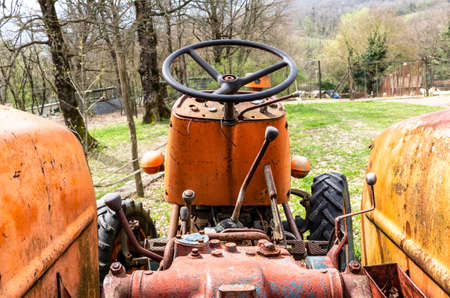 old orange tractor abandoned in a fieldの写真素材