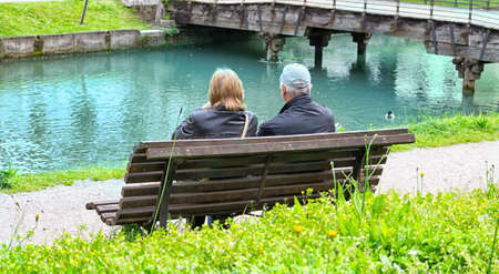 couple of adult people sitting on a benchの写真素材