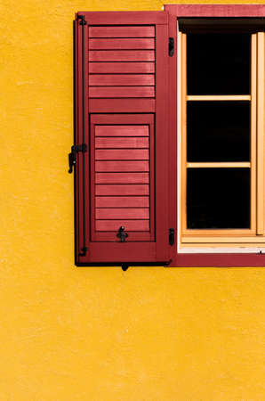 contrast between red window open on a yellow wallの写真素材