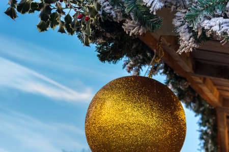 Christmas ball hanging on a roof with the background of blue skyの写真素材