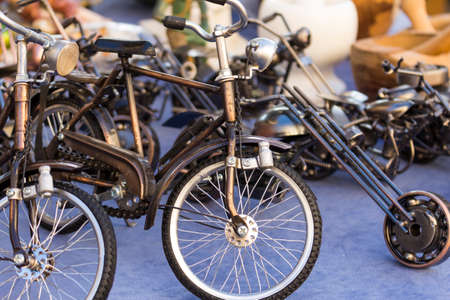 collection of little models of old steel bicycles displayed in an antiques market