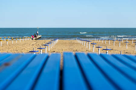 sea viewed from behind the jetty of a private beach with closed umbrellas
