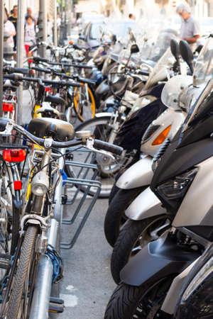 intertwining of bicycles and scooters parked in the city.の写真素材