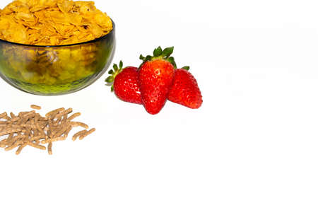 tasty cornflackes, strawberries and bran on a white background.