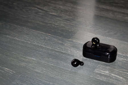 Black wireless earphones and the case isolated.の写真素材