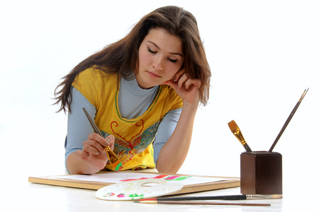 Woman artist draws a line on the paper lying on the floor facing the camera isolated against backgroundの写真素材