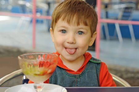 Little boy has eaten all the ice cream and showing tongueの写真素材