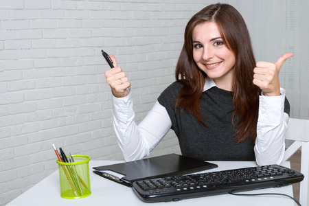 Girl in the workplace very happy and shows that all is wellの写真素材