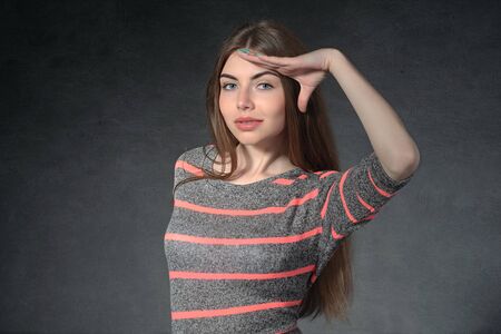 Concept human emotions. Girl shows curiosity against a dark backgroundの写真素材