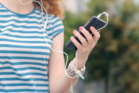 Tranquility, freedom, pleasure concept. The girl listens to music in her smartphoneの写真素材