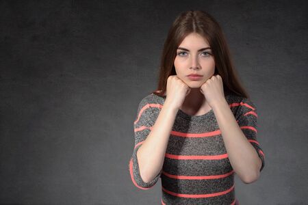 Concept human emotions. Girl shows concentration against a dark backgroundの写真素材
