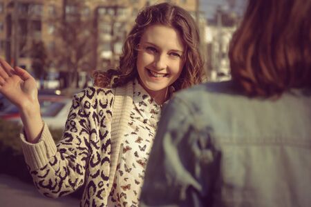 Photo in vintage style. The two girls met on the street on a background of the cityの写真素材