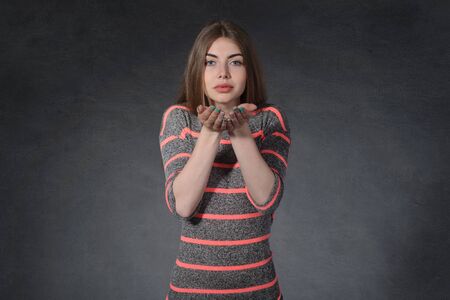 Kindness, thrift concept. Female clasped her hands together against the dark backgroundの写真素材