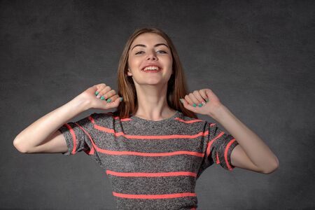 Concept human emotions. Woman shows happiness against a dark backgroundの写真素材