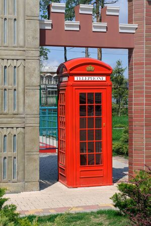 Red phone booth in a city park