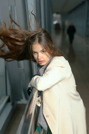 Girl leans on the rail until the wind blowing her hairの写真素材