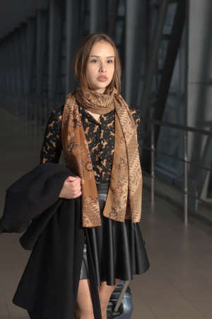 Girl is with a suitcase and a coat in hand at the station