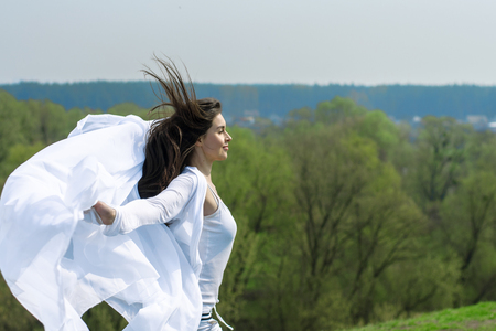 Girl doing hairstyle against the sky background. Concept: freedom, harmony, health.の写真素材