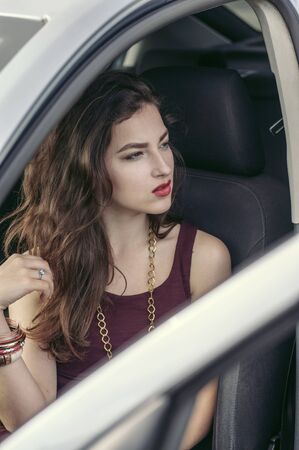 Woman gets out of the car. She opened the door and looking away. Concept: business, lifestyle,...