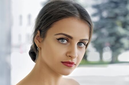 Close-up portrait of a girl with perfect clean skin against a light backgroundの写真素材