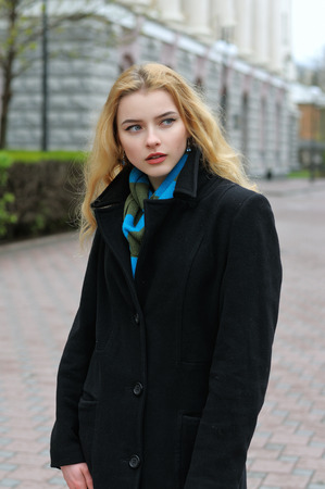 Fashion portrait of a beautiful blonde with long hair against urban architecture of classical styleの写真素材