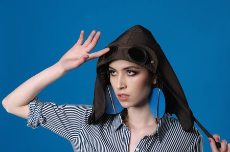 Studio portrait of a girl on the head of which is wearing a hood from a jacket stylized under a flying helmetの写真素材