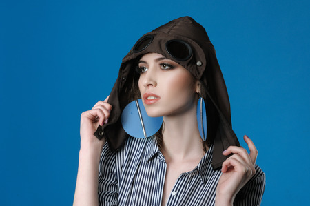 Studio portrait of a girl on the head of which is wearing a hood from a jacket stylized under a flying helmetの写真素材