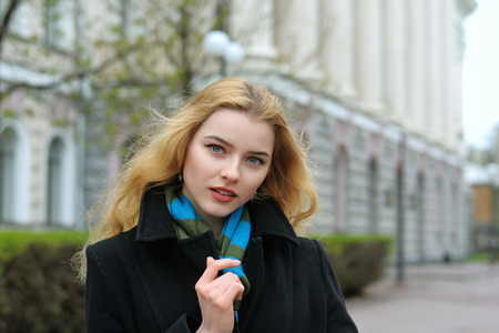 Fashion portrait of a beautiful blonde with long hair against urban architecture of classical styleの写真素材
