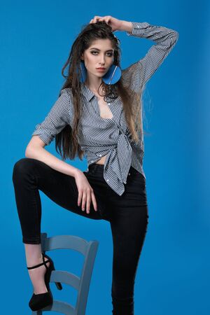Full-length portrait of a model who poses for tests against a blue background in the studioの写真素材