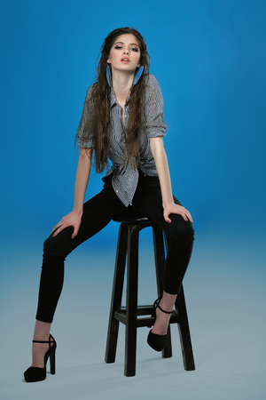 Full-length portrait of a model who poses for tests against a blue background in the studioの写真素材