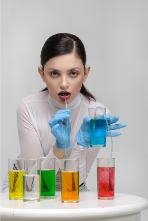 Fashion portrait of a girl who drinks unnatural fluids and spoils her healthの写真素材