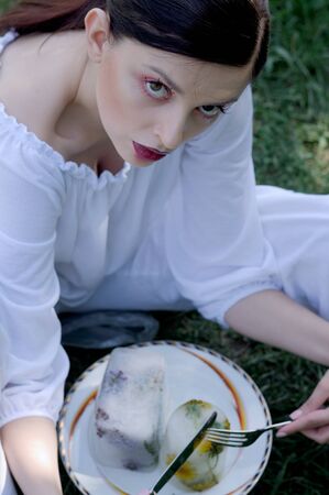 Fashion portrait of a girl who eats strange food instead of natural productsの写真素材