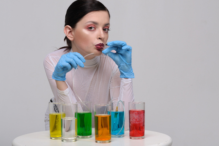 Fashion portrait of a girl who drinks chemical liquids instead of natural juicesの写真素材