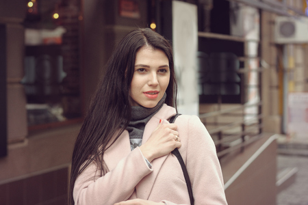 Model shows autumn clothes. She is dressed in a coat and has long brown hairの写真素材