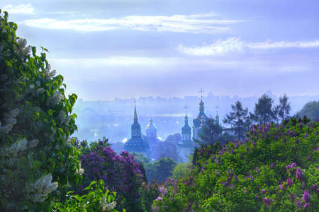 Vydubychi Monastery with blooming lilac against cloudy blue sky  の写真素材