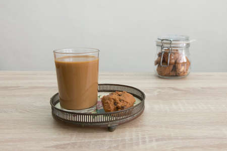 Coffee cup with milk jar on the wood table.
