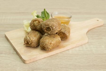 Fried crab dumpling on cutting board with sweet and sour sauce. の写真素材