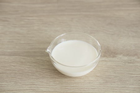 Milk in transparent cup are in the middle on a wood table.の写真素材