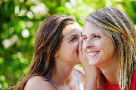 Pretty young brunette whispering in the ear of her mother Pretty young brunette whispering in the ear of her mother
