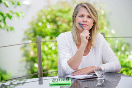 middle aged blond woman working at home without stress