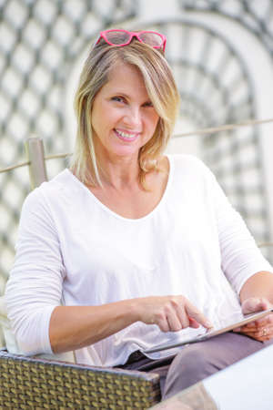 pretty blond woman looking at a digital tablet