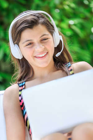 teenager with a laptop and headphones in the sofaの写真素材