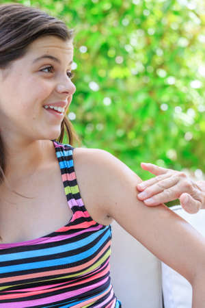closeup of young girl applying skin creamの写真素材
