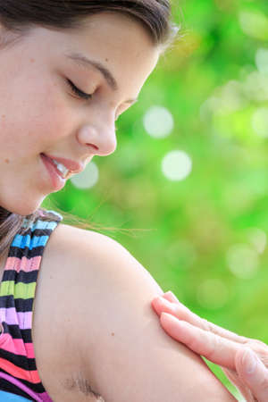 closeup of young girl applying skin creamの写真素材